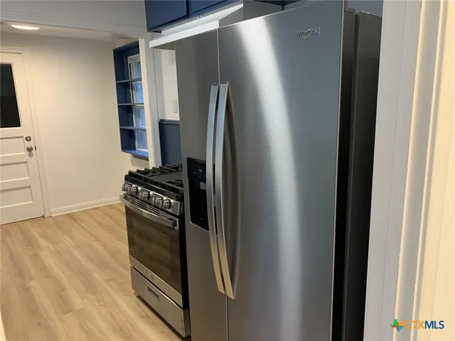 a kitchen with a refrigerator and a stove top oven