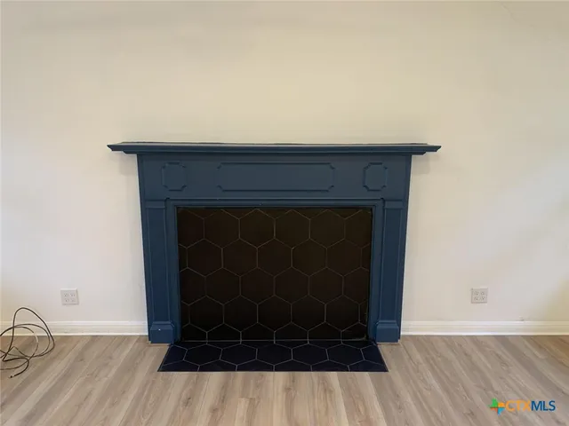 a room with a fireplace and wooden floor