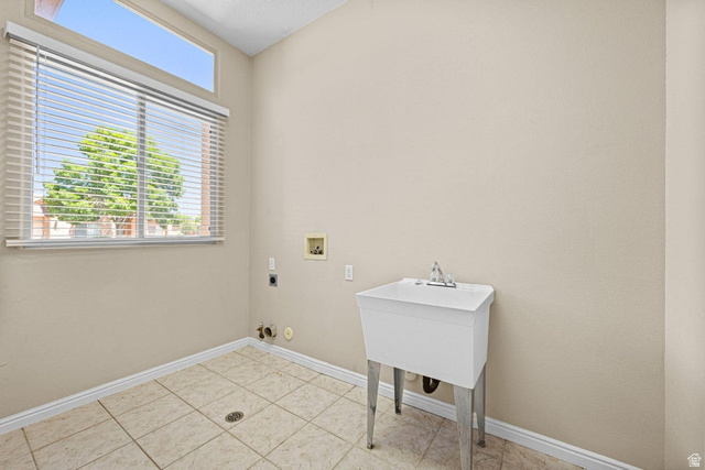 2226 East 140 South St. George, UT 84790 - Photo 12 of 20 Utility room featuring a laundry basin, tiled flooring, and a large window with horizontal blinds