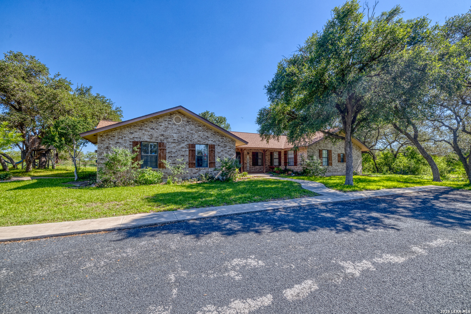 335 Sunset Ridge Road Uvalde, TX 78801 - Photo 1 of 8 a front view of a house with a big yard