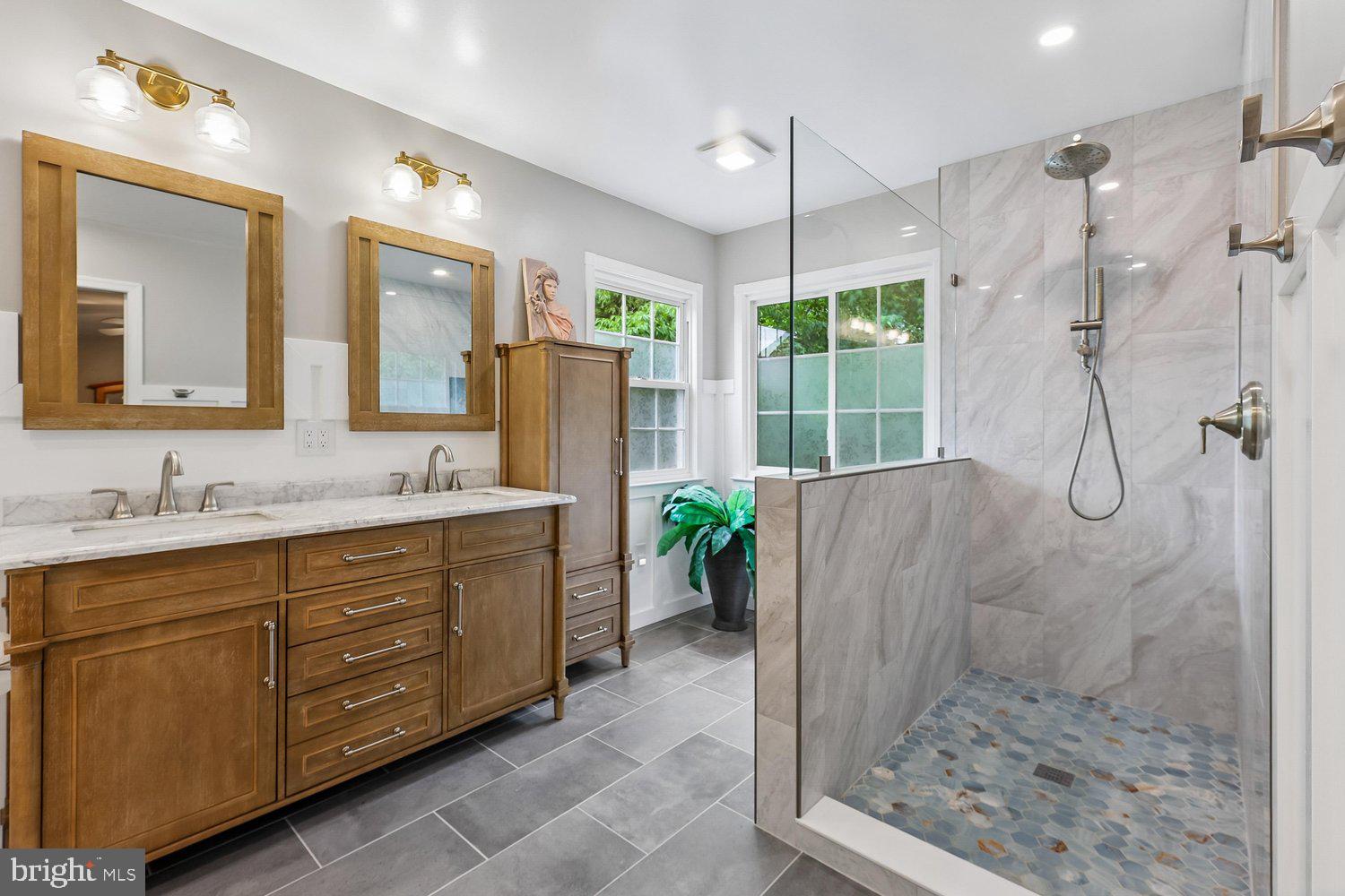 3707 Turn Back Trail Triangle, VA 22172 - Photo 31 of 55 a bathroom with a granite countertop sink a mirror a vanity and a shower