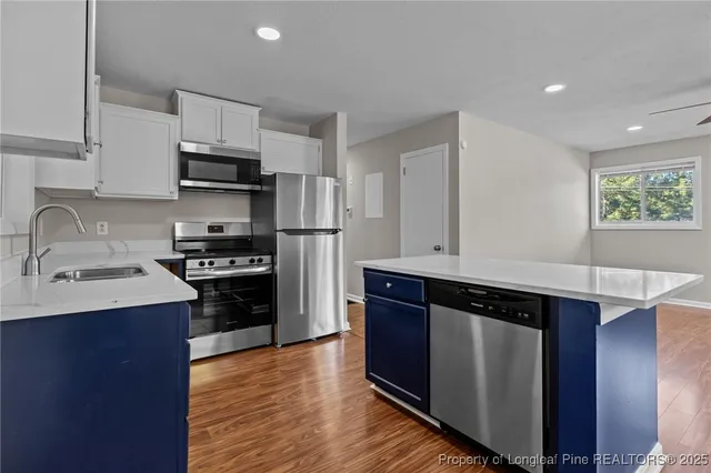 a kitchen with stainless steel appliances a sink stove and refrigerator