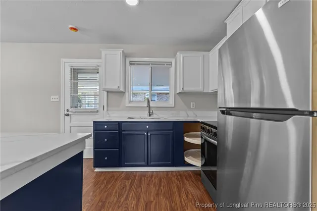 a kitchen with stainless steel appliances granite countertop a refrigerator sink and wooden cabinets