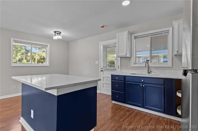 a kitchen with a sink a window and wooden cabinets