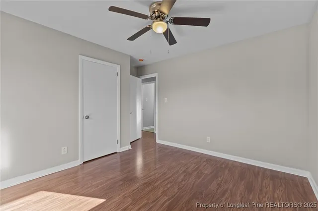 an empty room with wooden floor a ceiling fan and closet
