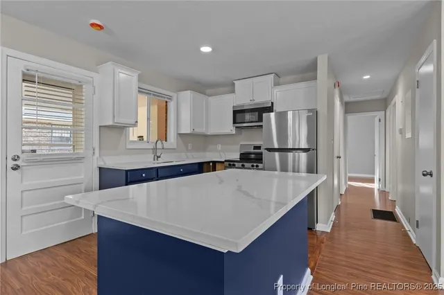 a kitchen with kitchen island sink refrigerator and cabinets