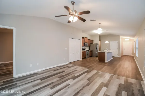 a view of a livingroom with a ceiling fan and wooden floor