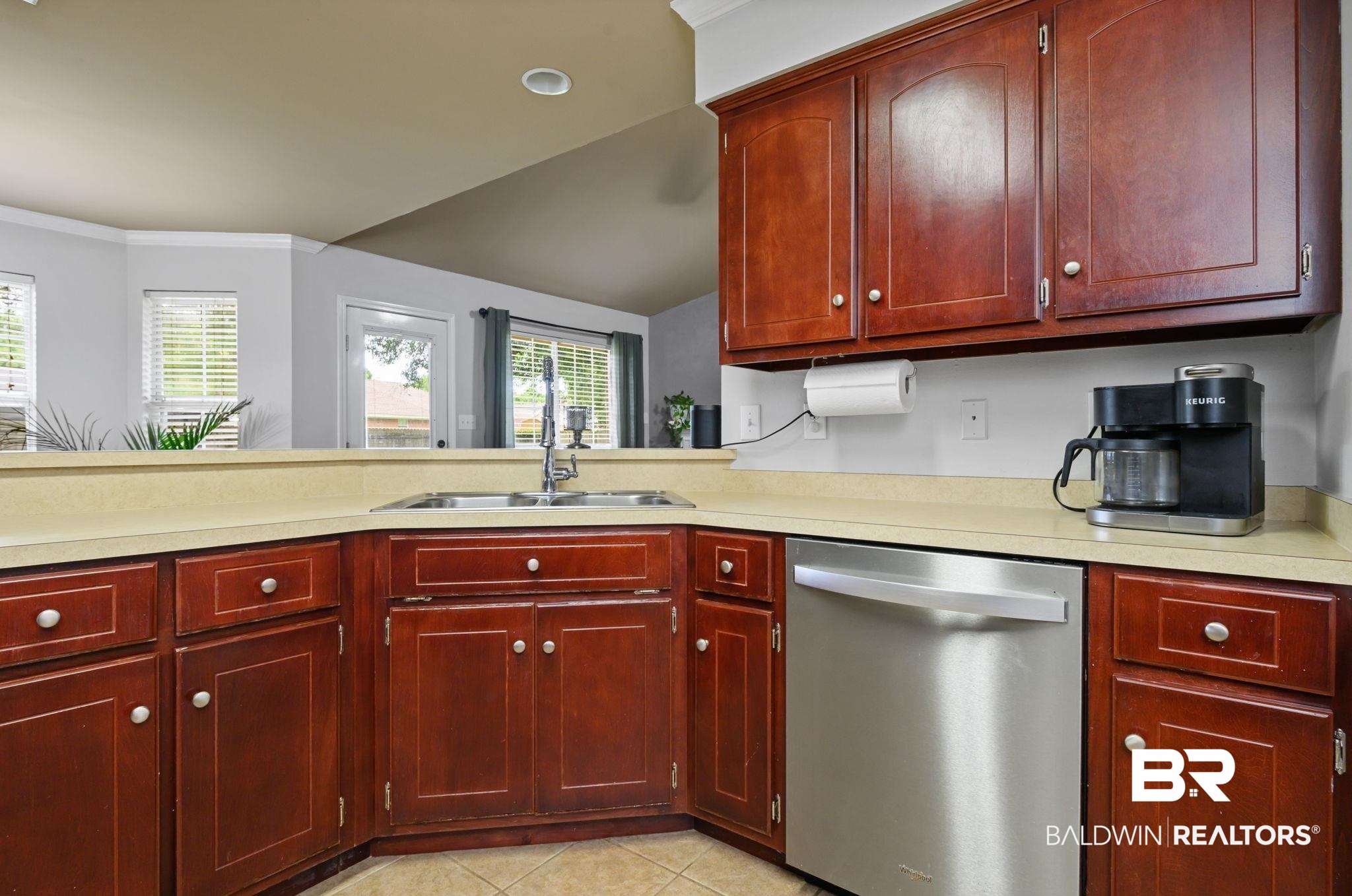 9422 Labrador Run South Mobile, AL 36695 - Photo 13 of 36 Kitchen featuring rich wood cabinetry, light-toned countertops, a stainless steel dishwasher, and a double basin sink with a gooseneck faucet