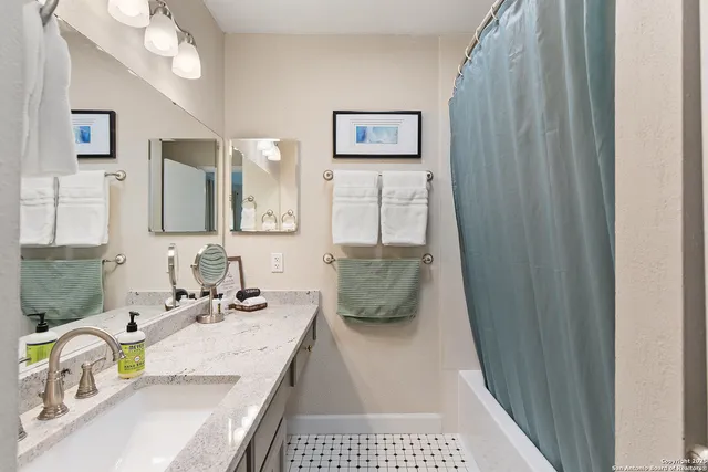 a bathroom with a granite countertop sink a toilet a mirror and vanity