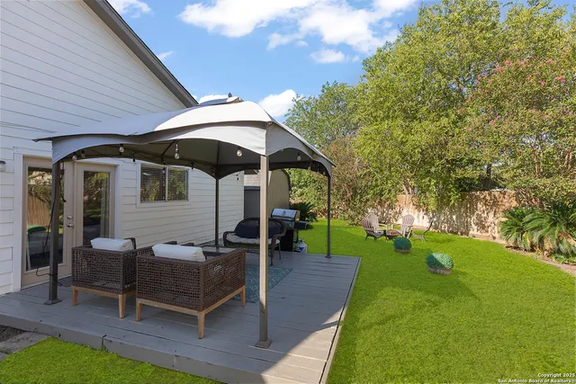 a view of a house with backyard and sitting area