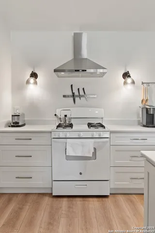 a kitchen with a stove cabinets and wooden floor