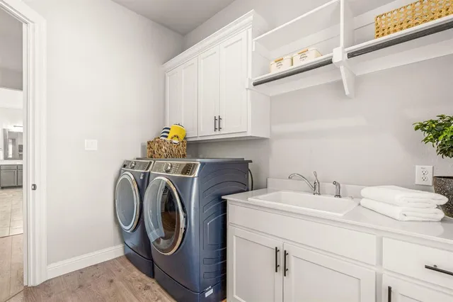a utility room with sink dryer and washer