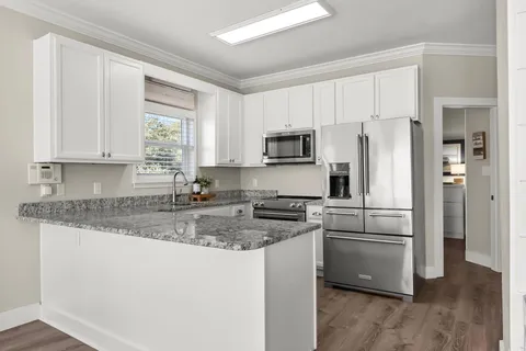 a kitchen with stainless steel appliances granite countertop a refrigerator stove microwave and sink