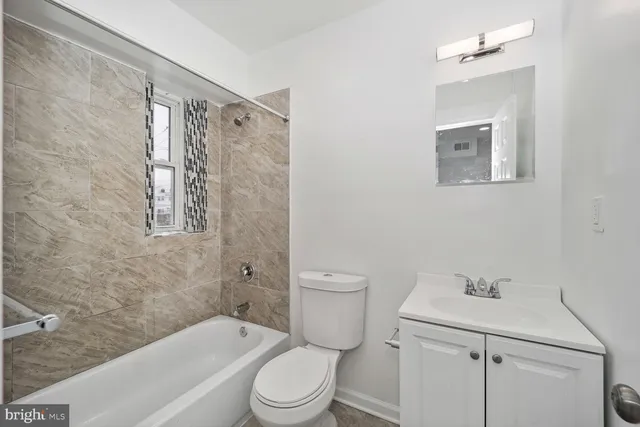 a bathroom with a toilet sink vanity tub and shower