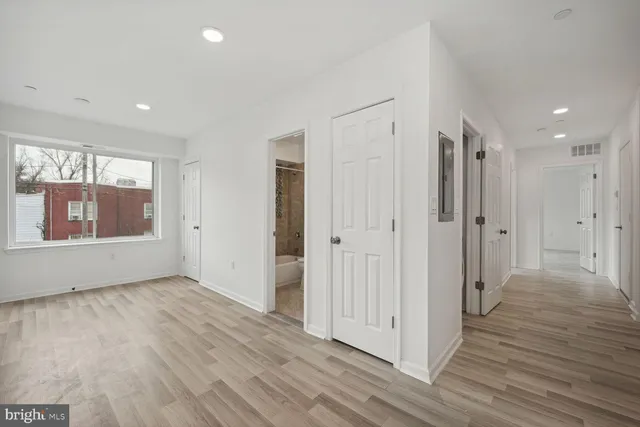 a view of a hallway with wooden floor and closet area