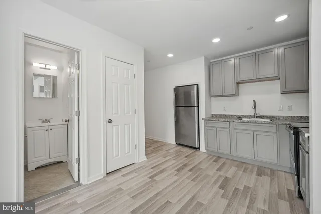 a kitchen with stainless steel appliances granite countertop a refrigerator and a stove top oven