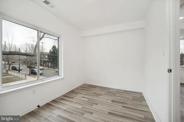 a view of a room with wooden floor and a window