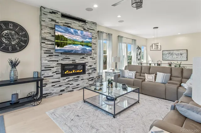 a living room with furniture a flat screen tv and a fireplace