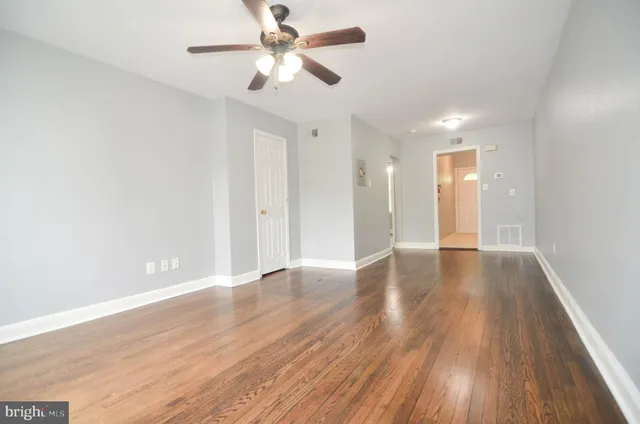 a view of an empty room with wooden floor