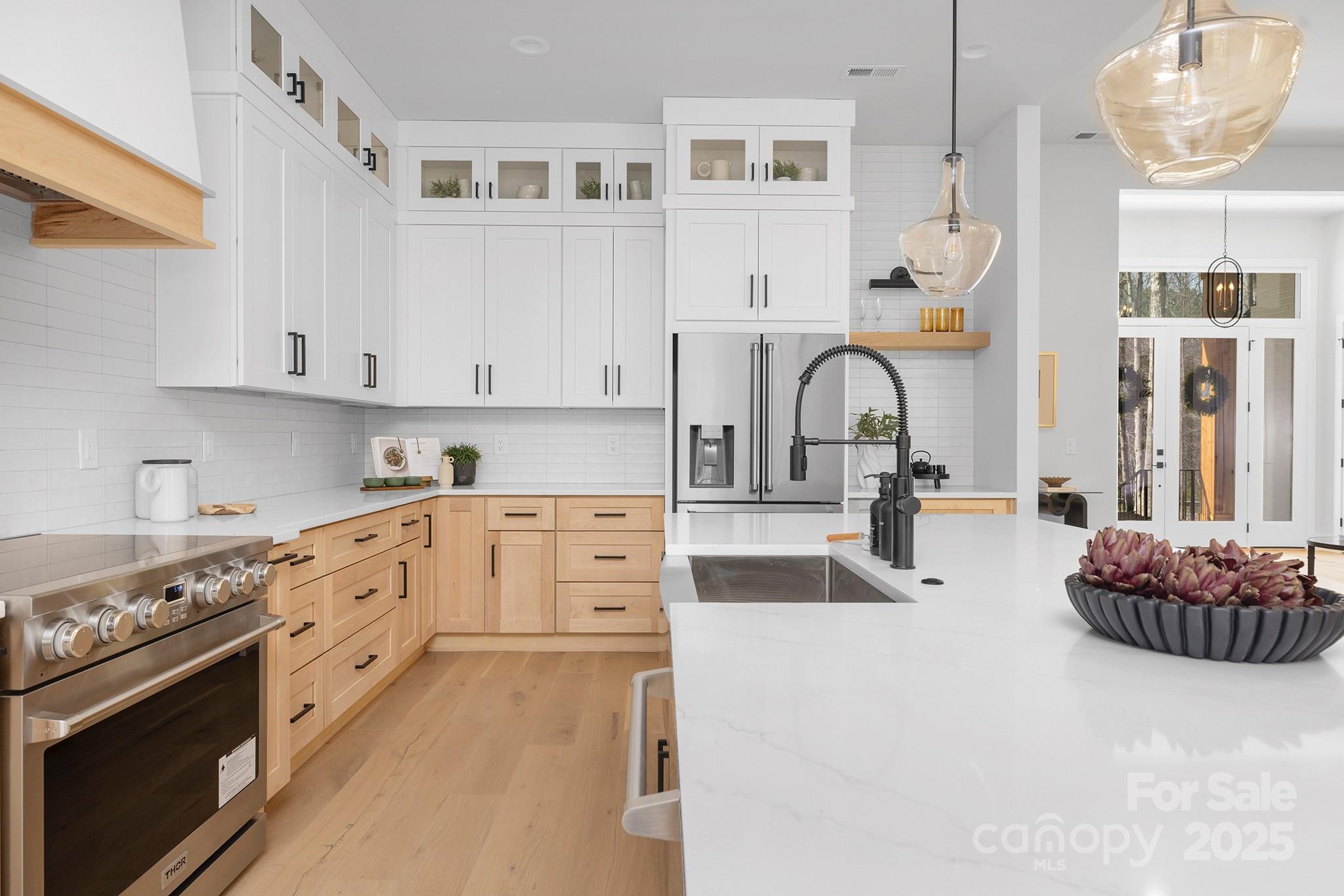 12011 Brief Road Charlotte, NC 28227 - Photo 6 of 12 a kitchen with stainless steel appliances kitchen island granite countertop a stove a sink dishwasher and white cabinets with wooden floor