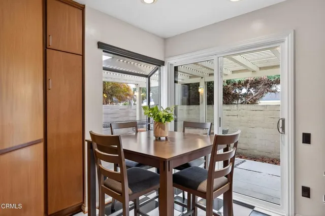 a dining room with furniture potted plants and wooden floor