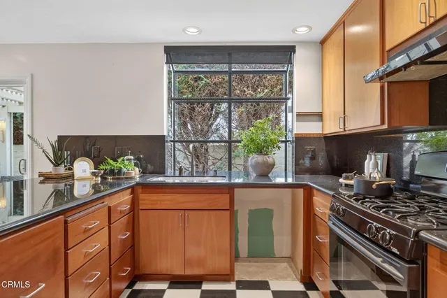a kitchen with stainless steel appliances a sink a stove and a window