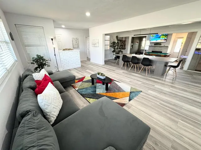 a living room with furniture chess floor and a kitchen view