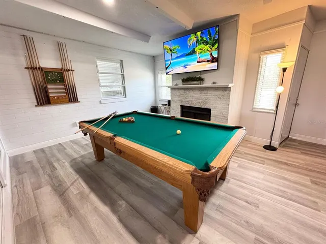 a room with pool table and windows