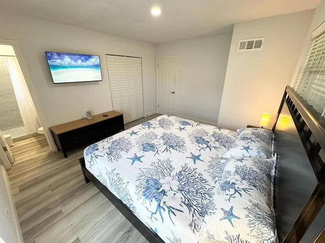 a bedroom with a bed and wooden floor