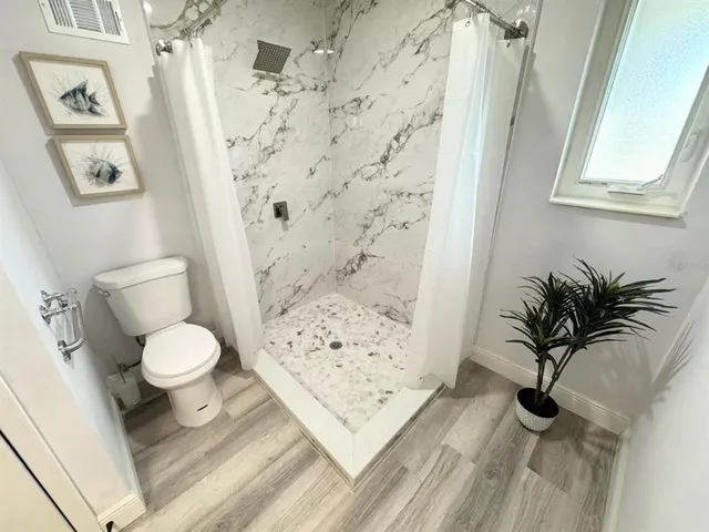 a bathroom with a toilet a sink and a shower curtain