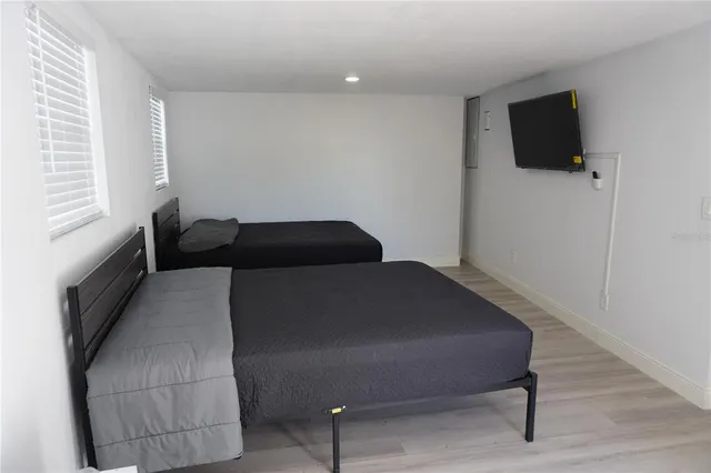 a bedroom with a bed tv and a window