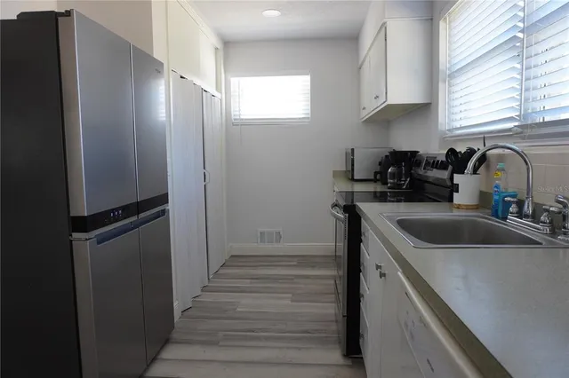 a kitchen with a refrigerator sink and cabinets