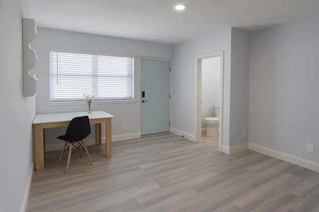 a view of a livingroom with wooden floor and a window