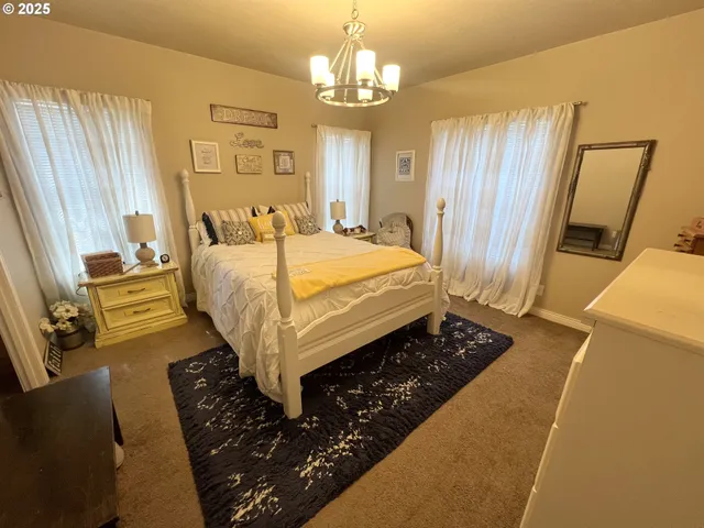 a bed sitting in a spacious bedroom next to a window