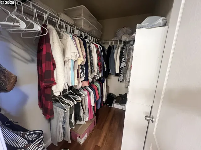 a view of walk in closet with clothes and shoes