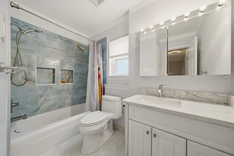 a bathroom with a granite countertop sink toilet and shower