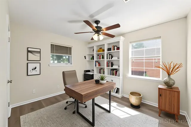 a view of a workspace with furniture and a window