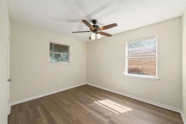 a view of a big room with wooden floor and a chandelier fan