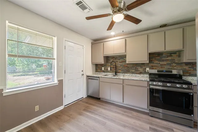 a kitchen with stainless steel appliances granite countertop a stove and a sink