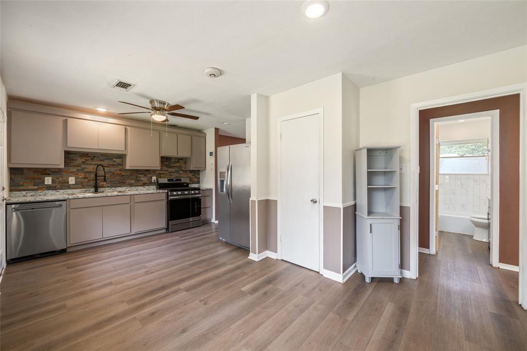 604 Pershing Drive Denton, TX 76209 - Photo 18 of 24 a kitchen with granite countertop a refrigerator and wooden floor