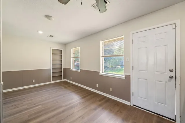an empty room with windows and closet