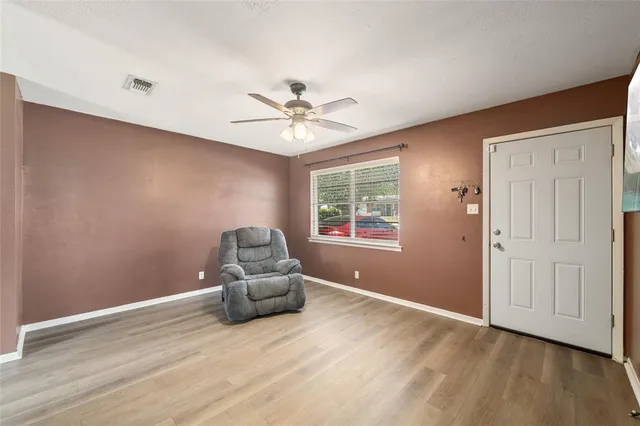 an empty room with windows and ceiling fan