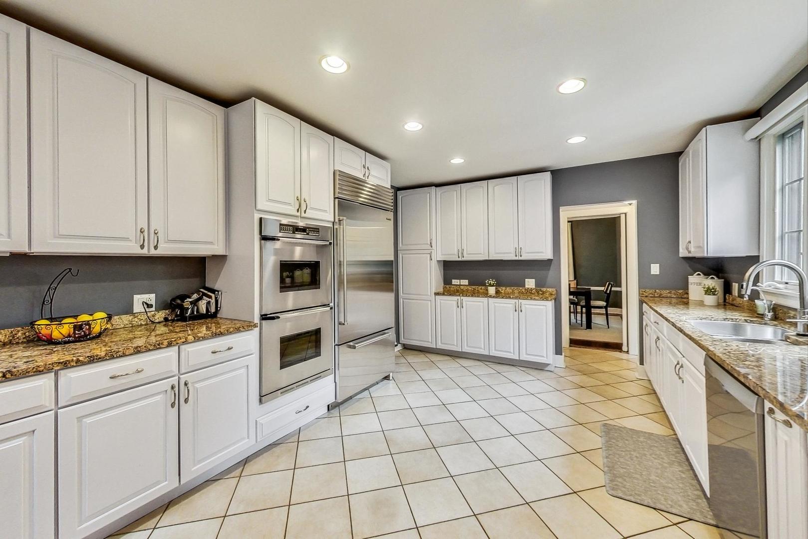 929 Valley Road Glencoe, IL 60022 - Photo 11 of 46 a kitchen with stainless steel appliances granite countertop a refrigerator and a stove top oven