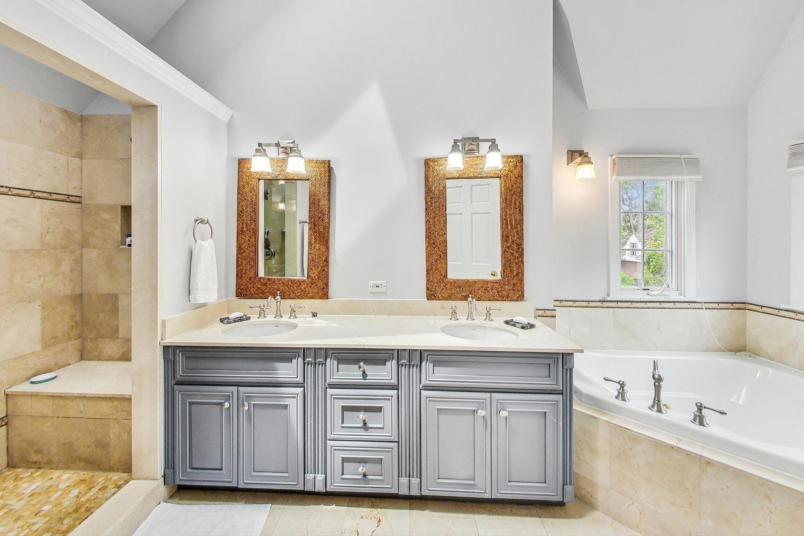 929 Valley Road Glencoe, IL 60022 - Photo 21 of 46 a bathroom with a granite countertop double vanity sink a mirror and a bathtub