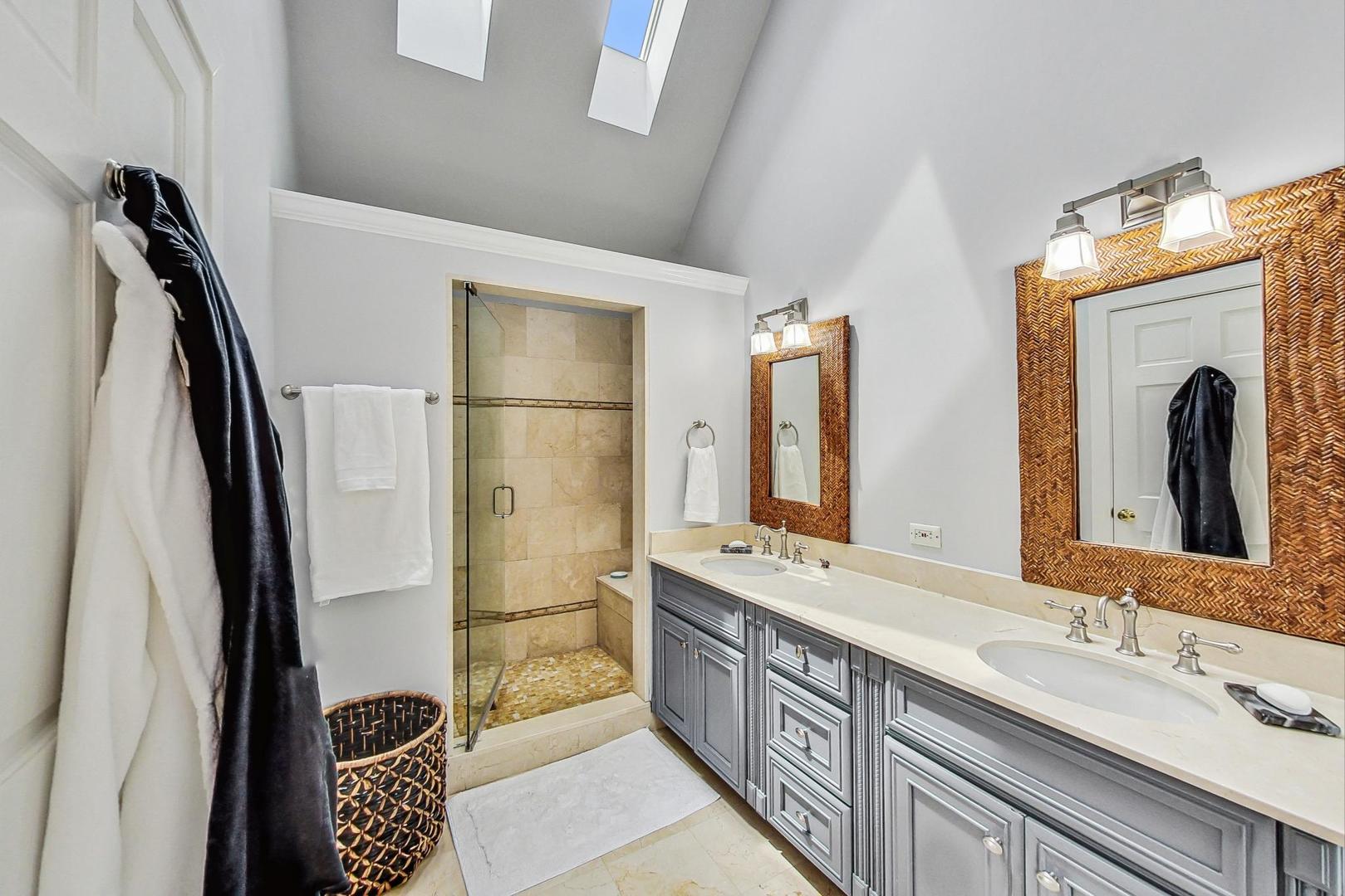 929 Valley Road Glencoe, IL 60022 - Photo 22 of 46 a bathroom with a double vanity sink a mirror and shower