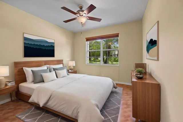 a bedroom with a bed a window and a flat screen tv