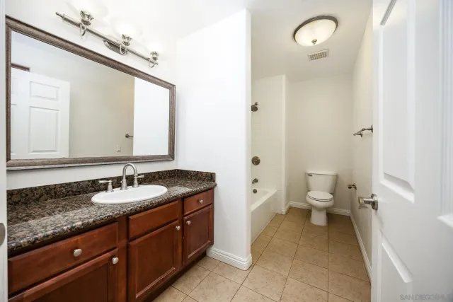 a spacious bathroom with a granite countertop sink and a mirror