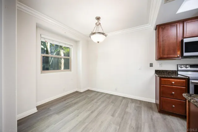 a view of a kitchen with wooden floor cabinet and a window