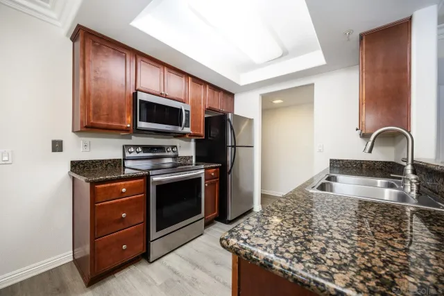 a kitchen with granite countertop wooden cabinets and stainless steel appliances