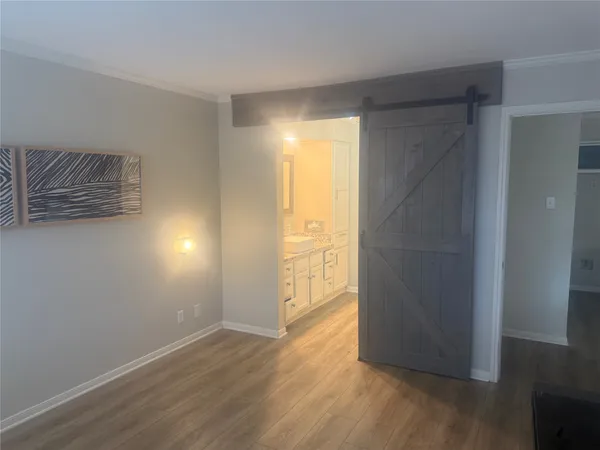 an empty room with wooden floor and door